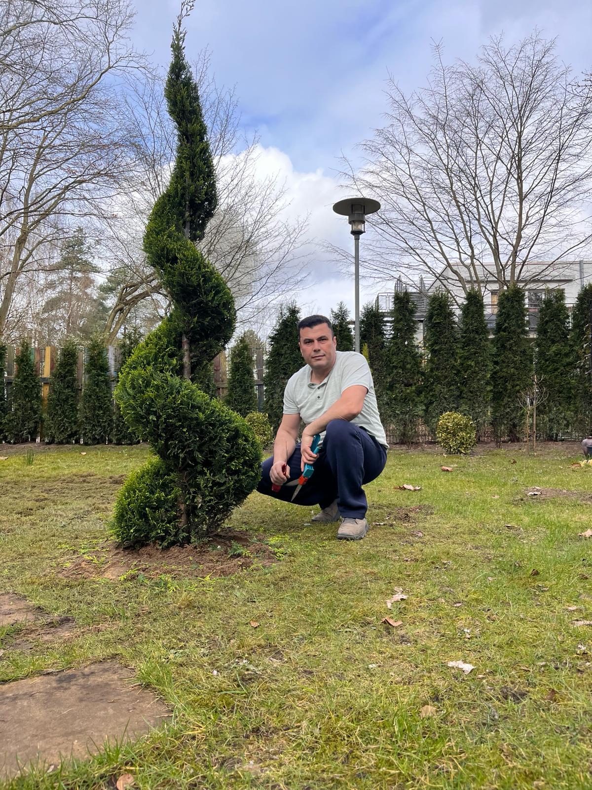 Rasenpflege durch professionellen Gärtner: Mähen, Kanten schneiden und düngen.